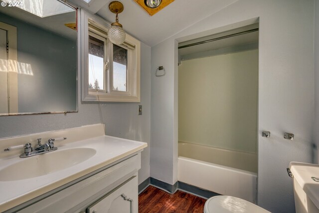 full bathroom with shower / bath combination, vanity, hardwood / wood-style flooring, toilet, and lofted ceiling