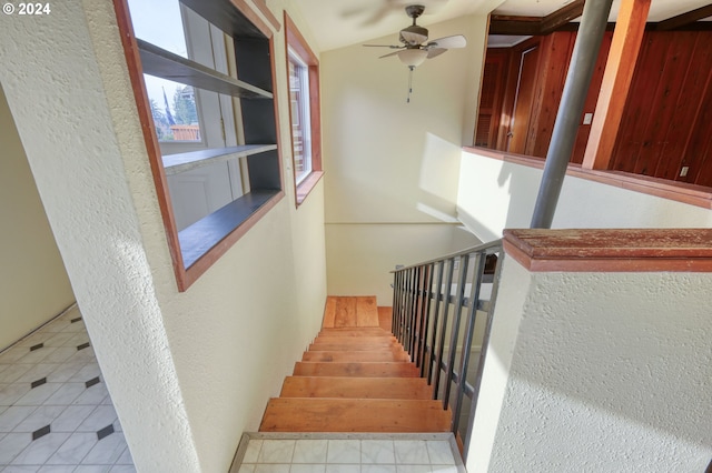 stairs featuring tile patterned floors, ceiling fan, and vaulted ceiling