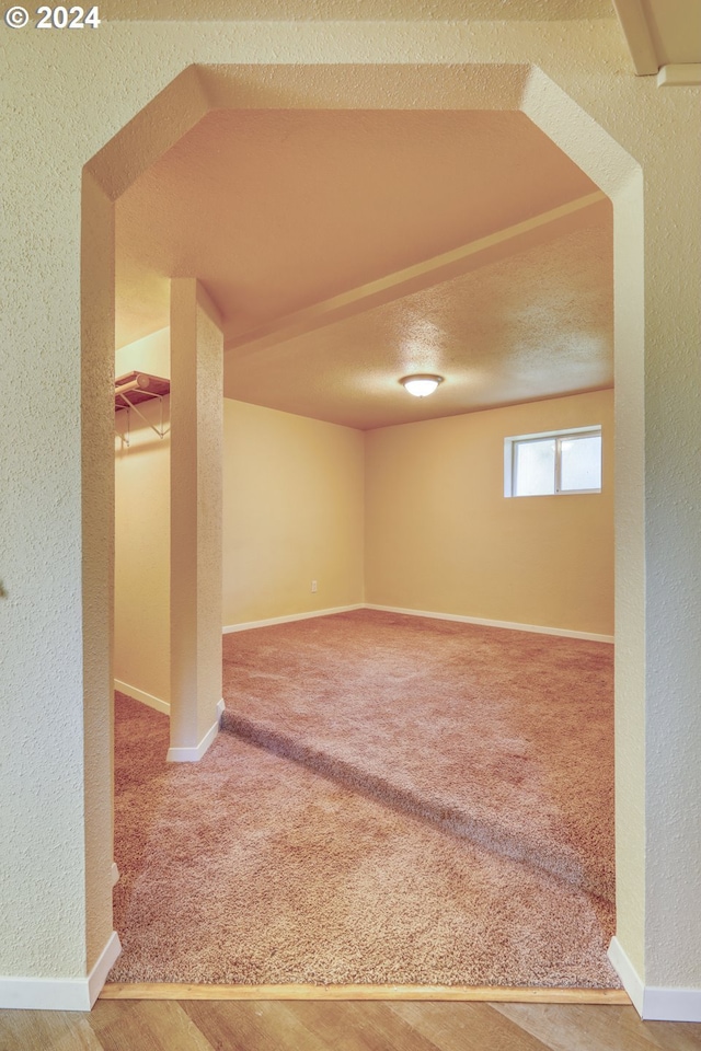 basement with carpet flooring and a textured ceiling