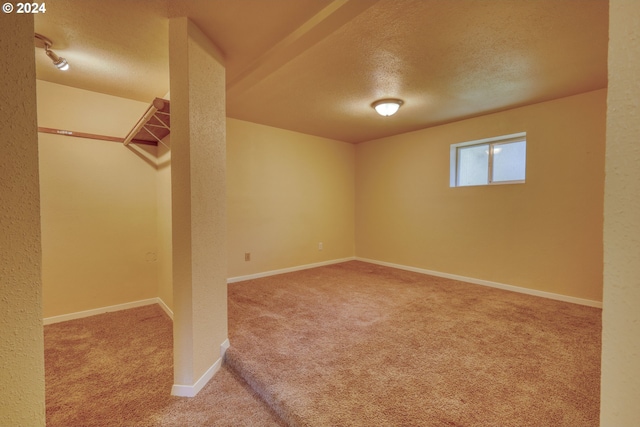 basement with carpet flooring and a textured ceiling