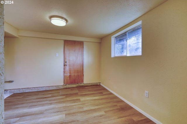 empty room with a textured ceiling and light wood-type flooring