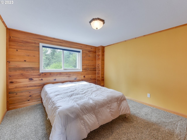 carpeted bedroom featuring baseboards and wood walls