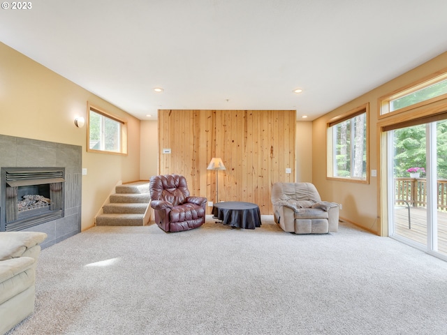 sitting room featuring recessed lighting, stairway, carpet floors, and a tiled fireplace