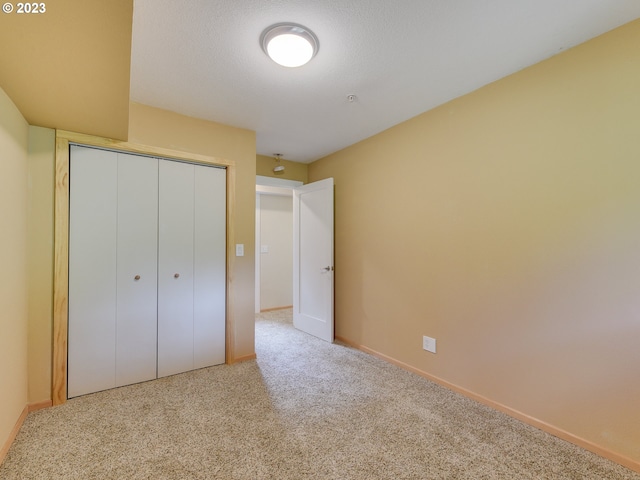 unfurnished bedroom featuring a closet, carpet floors, and baseboards