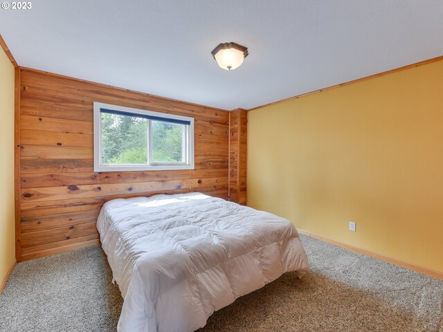 bedroom with carpet flooring and wood walls