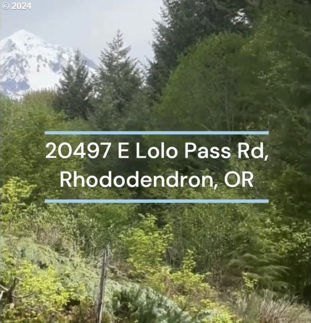 community / neighborhood sign featuring a wooded view and a mountain view