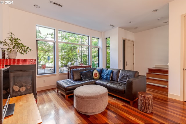 living room with a tile fireplace and wood-type flooring