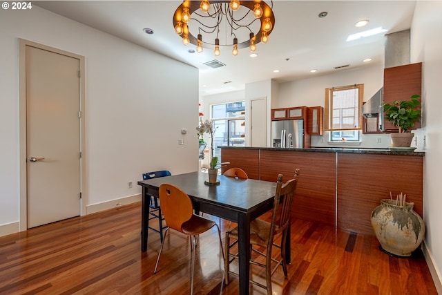 dining room with dark wood-type flooring and a notable chandelier