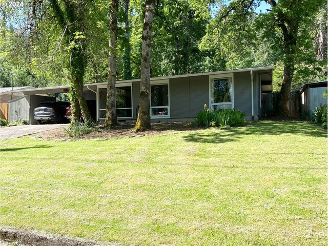 ranch-style home featuring a carport and a front lawn