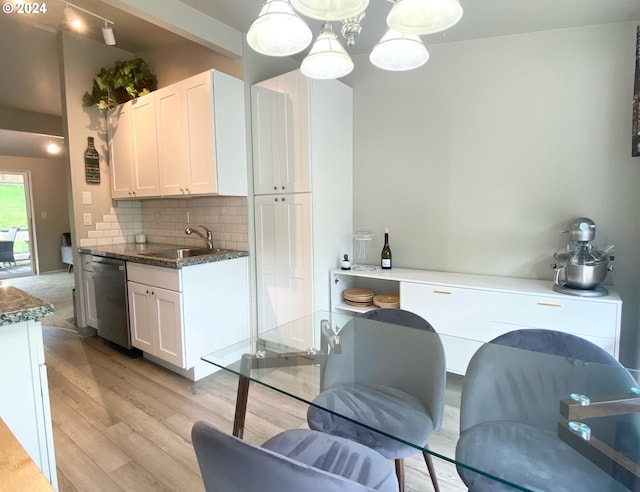 kitchen featuring light wood-style flooring, a sink, white cabinetry, backsplash, and dishwasher