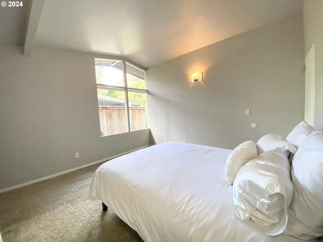 carpeted bedroom with lofted ceiling with beams and baseboards