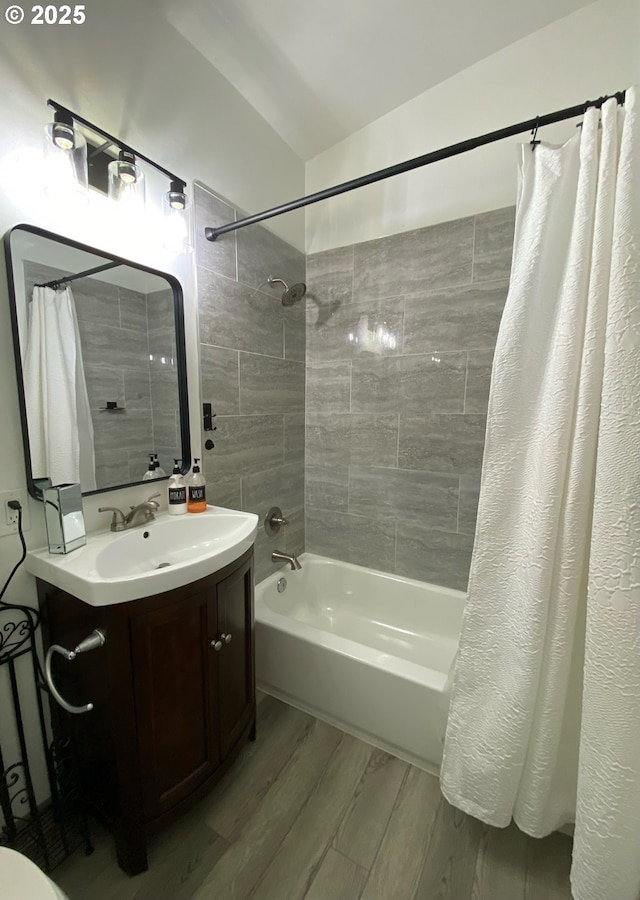 full bath with shower / bath combo with shower curtain, vanity, and wood finished floors