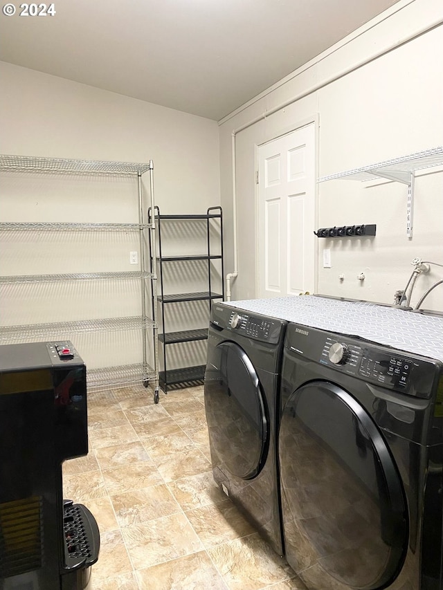 laundry area featuring laundry area, washing machine and dryer, and stone finish flooring