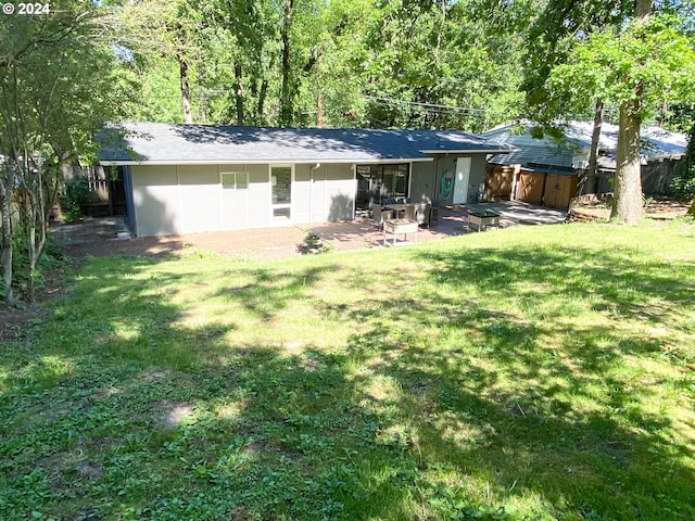 back of property with a patio area, fence, and a lawn