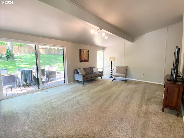 living area with light carpet, beam ceiling, and baseboards