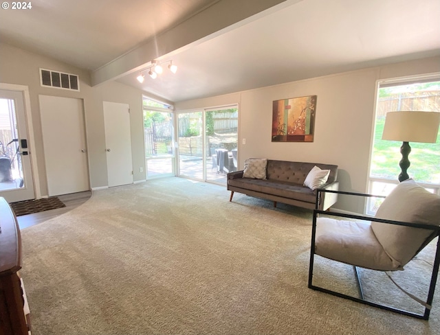 carpeted living room featuring vaulted ceiling with beams, visible vents, and baseboards