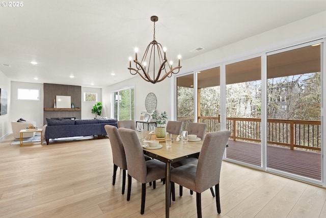 dining space with light wood-style floors, a notable chandelier, visible vents, and recessed lighting