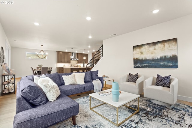 living area with recessed lighting, a notable chandelier, visible vents, and light wood-style flooring