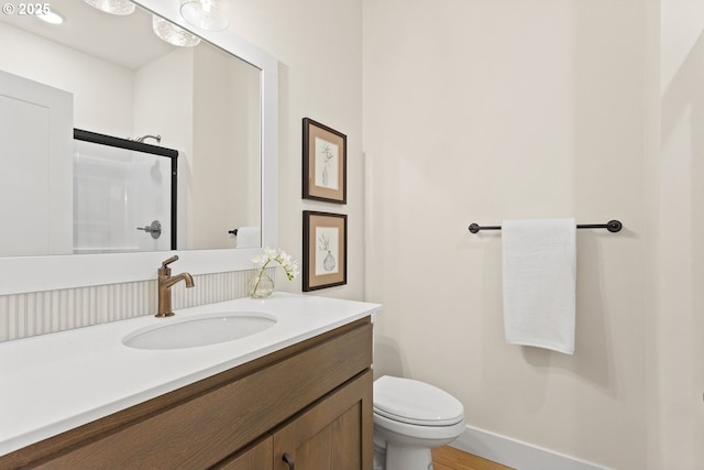 full bathroom featuring an enclosed shower, toilet, vanity, and baseboards