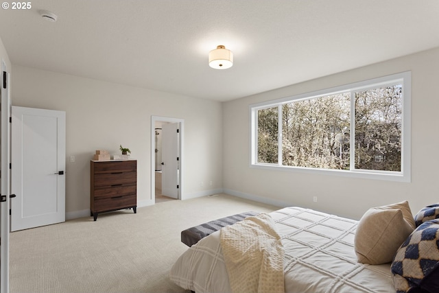 bedroom featuring light colored carpet and baseboards