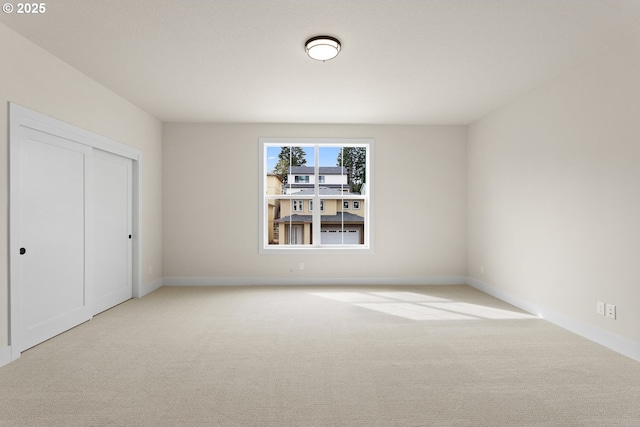 unfurnished bedroom with carpet floors, baseboards, and a closet