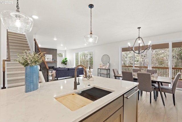 kitchen with a sink, recessed lighting, an inviting chandelier, and decorative light fixtures