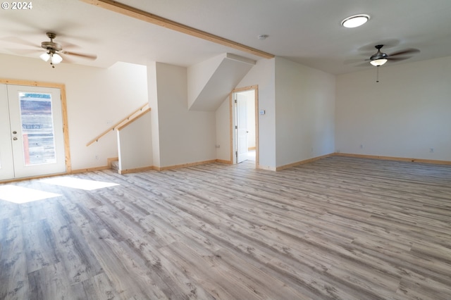 additional living space with stairway, light wood-style flooring, baseboards, and a ceiling fan