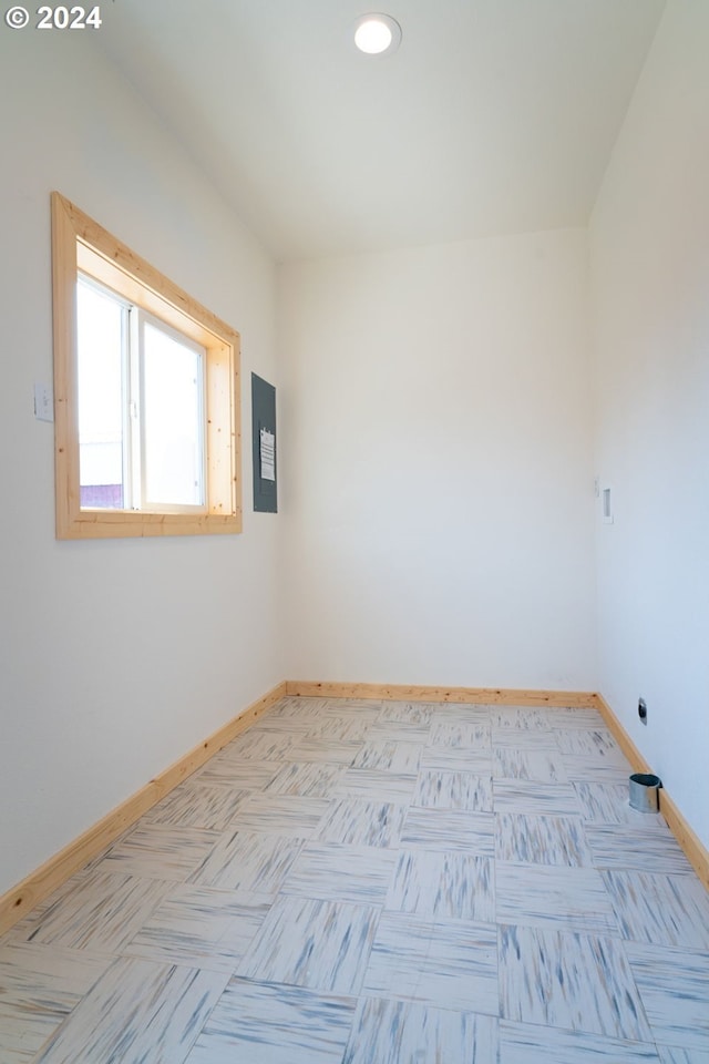 unfurnished room with electric panel and baseboards