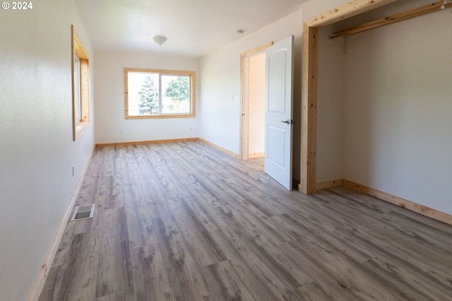 unfurnished bedroom with baseboards, visible vents, and wood finished floors