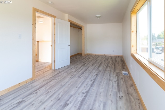 unfurnished room with light wood-type flooring, baseboards, and visible vents