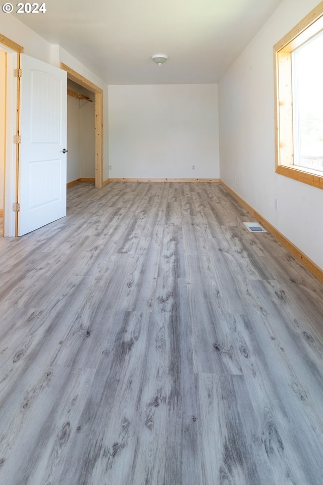 spare room with baseboards, visible vents, and light wood finished floors