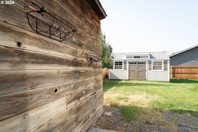 view of yard featuring an outdoor structure, a storage shed, and fence