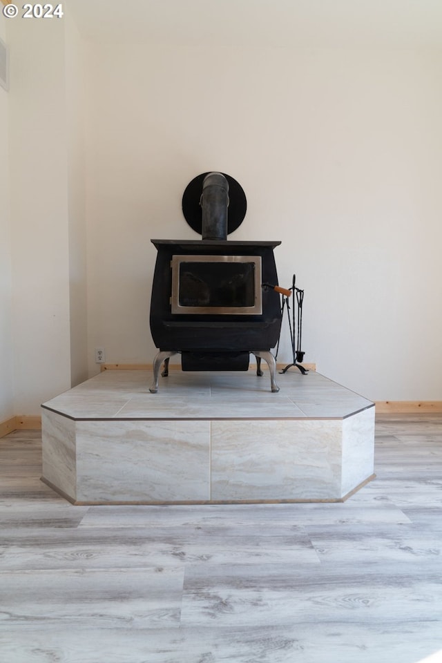 details with wood finished floors, a wood stove, and baseboards