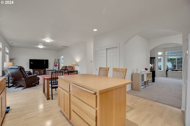 kitchen with light carpet, light brown cabinets, and a center island