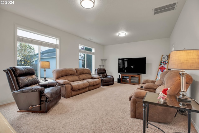 carpeted living room featuring a wealth of natural light and lofted ceiling