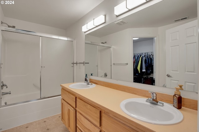 bathroom featuring tile patterned flooring, vanity, and bath / shower combo with glass door