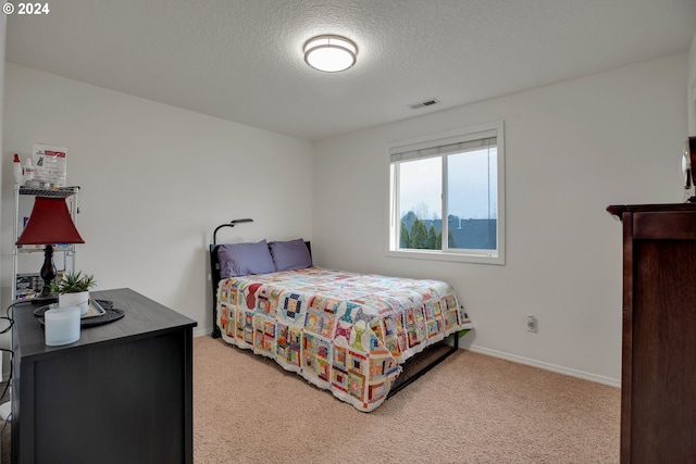 carpeted bedroom featuring a textured ceiling