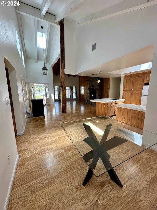 kitchen with white fridge, kitchen peninsula, hanging light fixtures, and a high ceiling