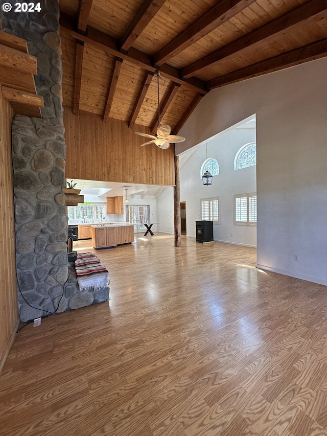 unfurnished living room with wooden ceiling, high vaulted ceiling, ceiling fan, light wood-type flooring, and beamed ceiling