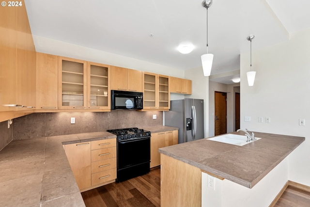 kitchen featuring sink, kitchen peninsula, black appliances, decorative light fixtures, and light brown cabinetry