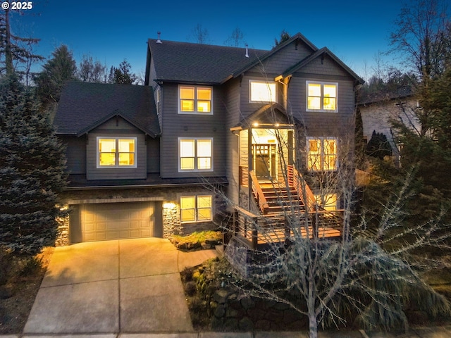 view of front of home with a garage, stairs, concrete driveway, stone siding, and roof with shingles