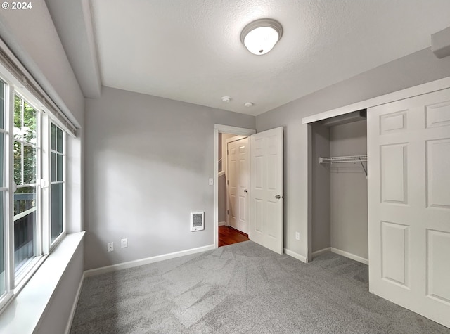 unfurnished bedroom featuring carpet flooring and a closet