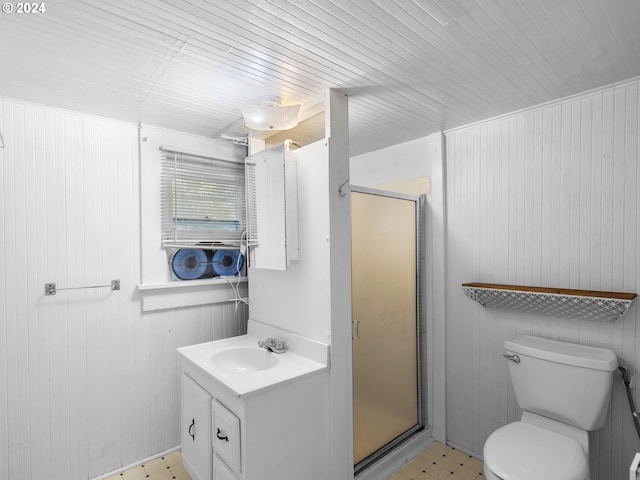 bathroom featuring toilet, wood walls, walk in shower, and vanity