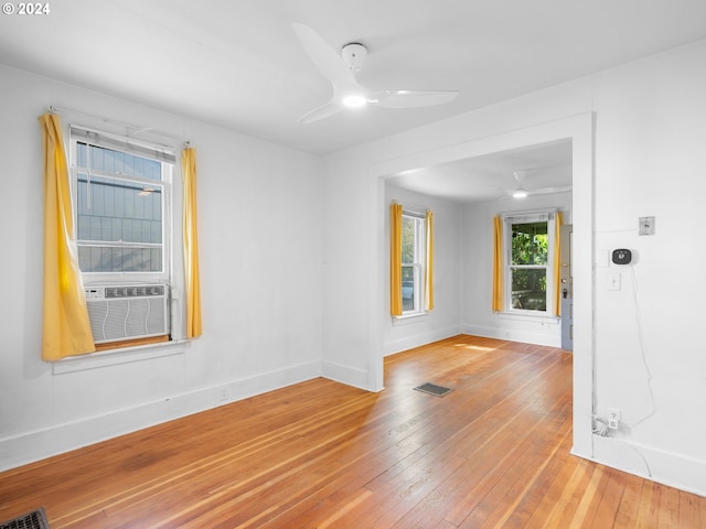 unfurnished room featuring cooling unit, hardwood / wood-style flooring, and ceiling fan