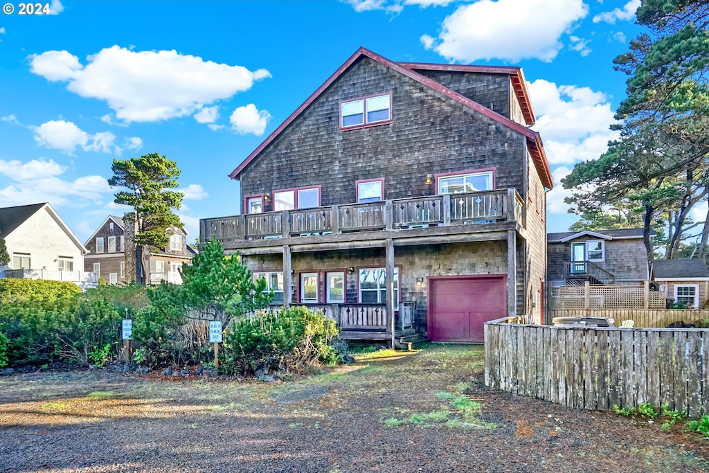 back of house featuring a balcony and a garage