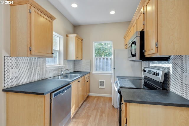 kitchen with sink, stainless steel appliances, light hardwood / wood-style floors, decorative backsplash, and light brown cabinetry