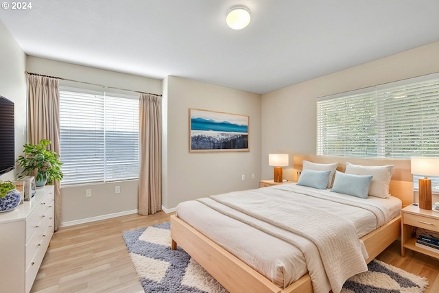 bedroom with light hardwood / wood-style flooring and multiple windows