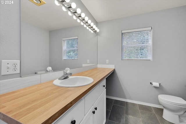 bathroom featuring vanity, a healthy amount of sunlight, and toilet