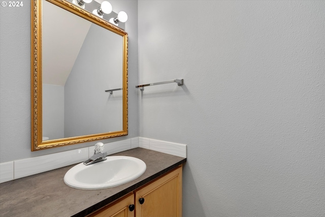 bathroom featuring vanity and lofted ceiling