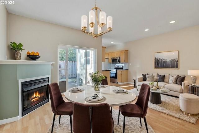 dining area with light wood-type flooring and a chandelier